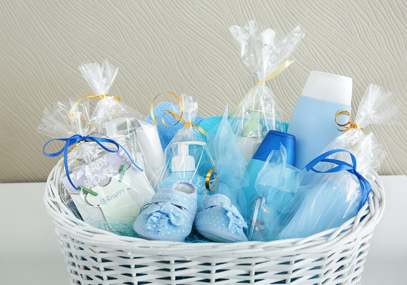 Witte mand met babyshowercadeaus in blauw thema