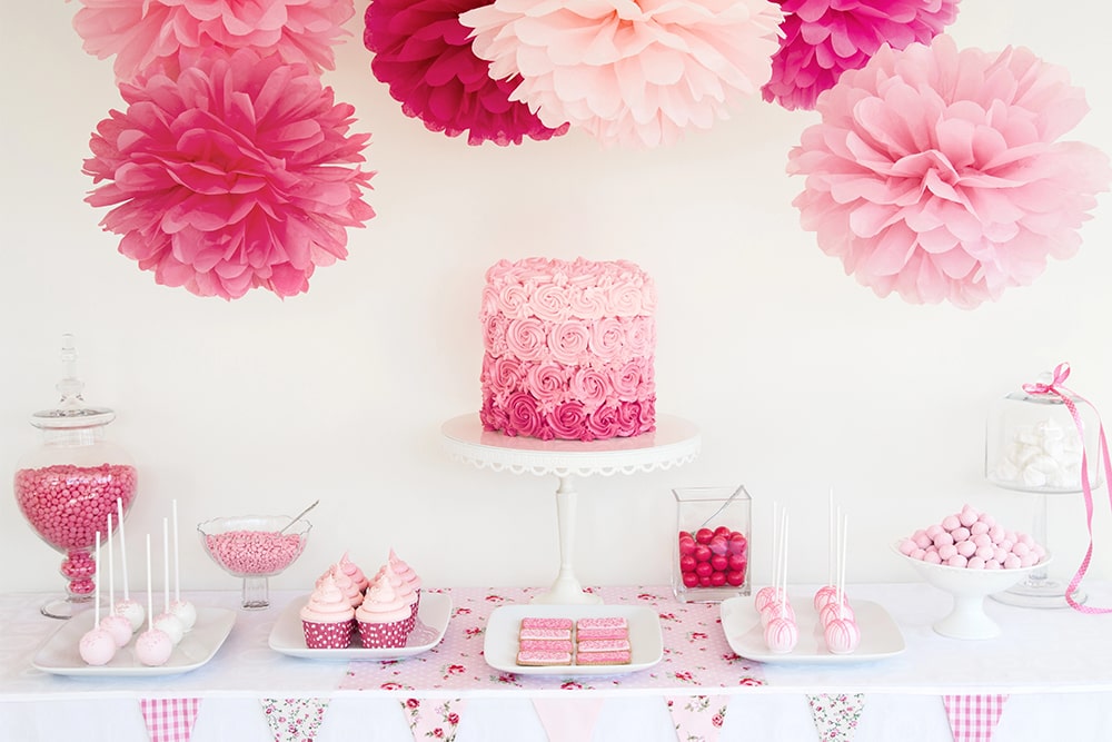 Zoete tafel in roze babyshowerstijl met cakepops, taart en glazen potten met snoep